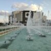 a large water fountain in front of a large building