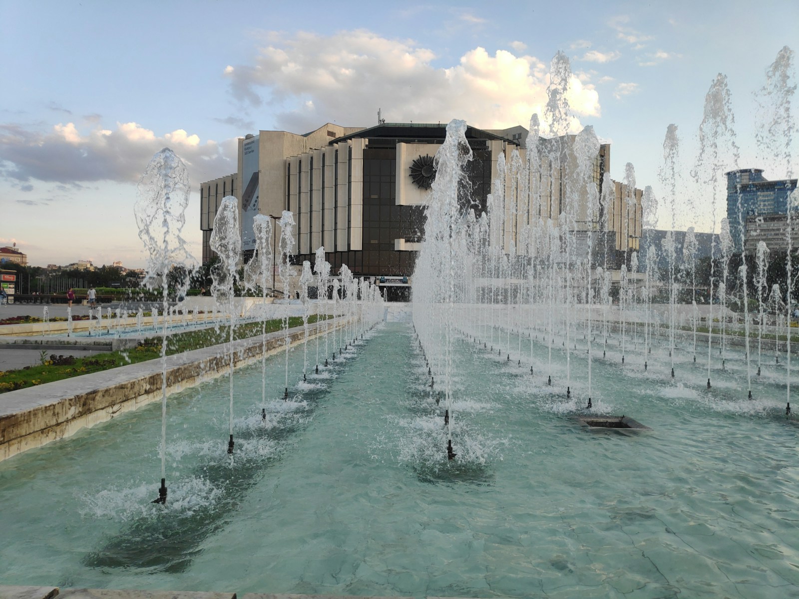 a large water fountain in front of a large building